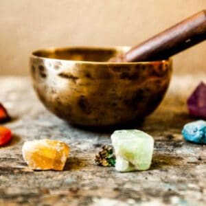 Chakra affirmation healing course - colourful chakra crystals with singing bowl used in energy aware practices and meditation