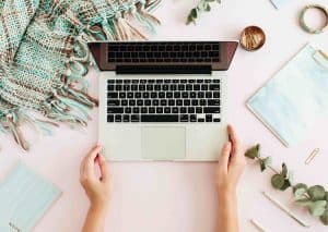 Hands working on a laptop with coaching resources, representing an online ultimate coaching toolbox