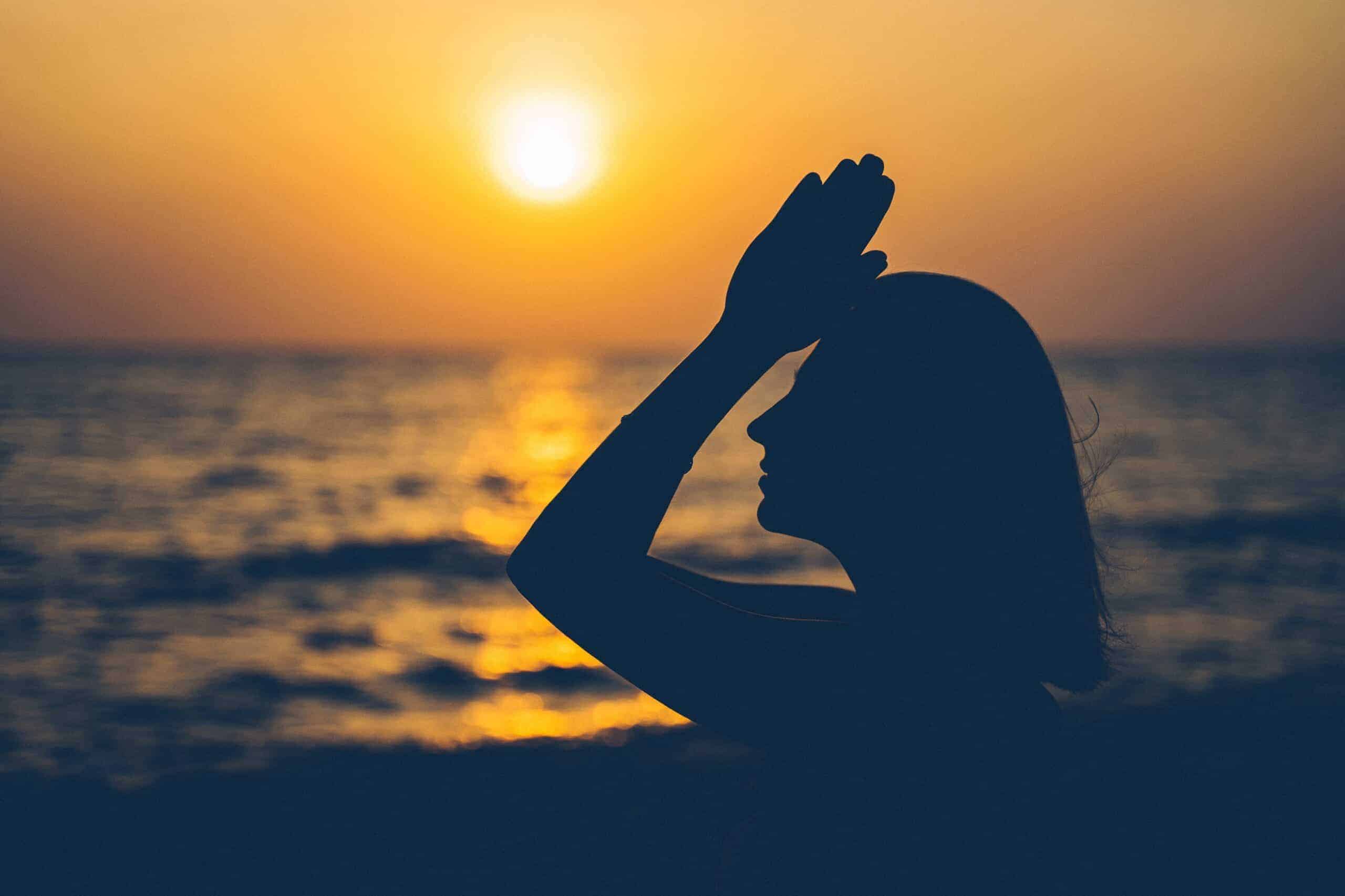 woman meditating at sunset - accredited spiritual life coaching course by Soul Awakening Academy UK, integrating meditation, mindfulness, chakras, and trauma-informed coaching with online certification.