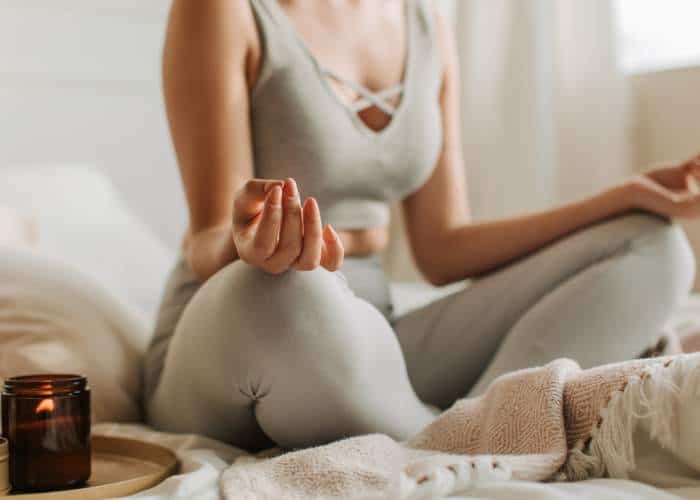 Woman meditating indoors - promoting the accredited Meditation Teacher Diploma by Soul Awakening Academy UK & Worldwide.