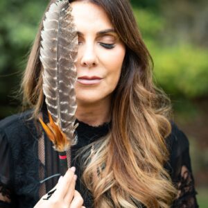 Anne-Marie Mayers, owner of Soul Awakening Academy holding a feather during a spiritual healing ritual - Oracle Master Certification Pack accredited course training.